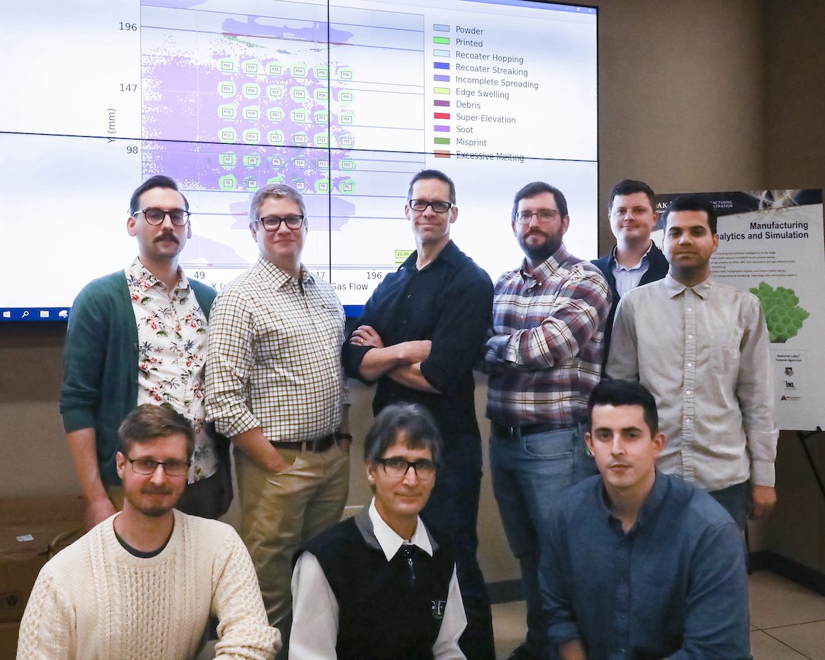 ECP's ExaAM project team in front of a screen from ExaAM